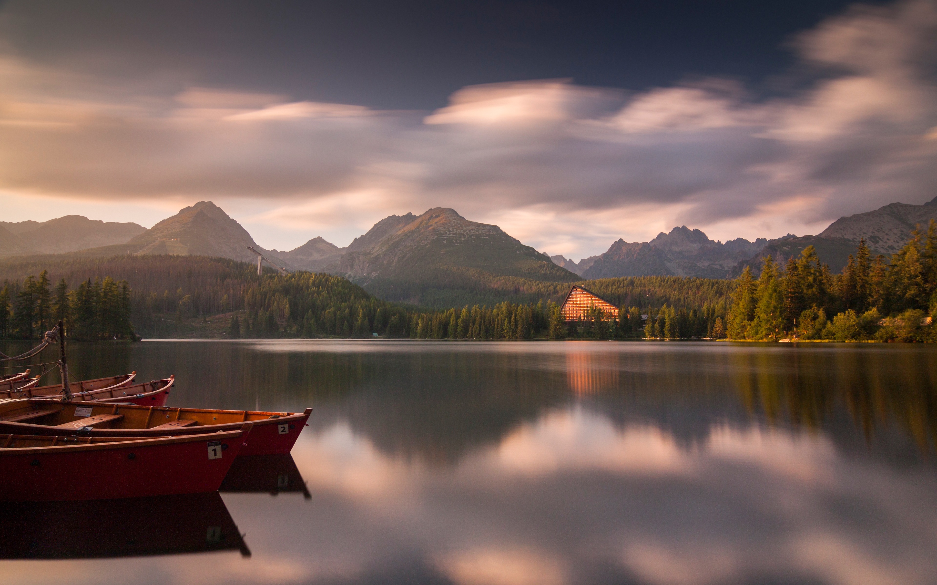 Serene mountain lake with boats reflecting tranquil financial planning